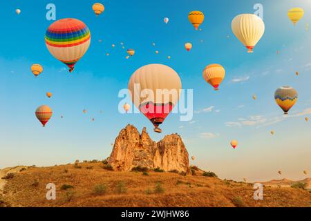 Bei Sonnenaufgang in der Türkei füllen die Luftballons Kappadokiens das Rose Valley of Goreme mit einer farbenfrohen und bezaubernden Darstellung, eine harmonische Verschmelzung der Natur Stockfoto