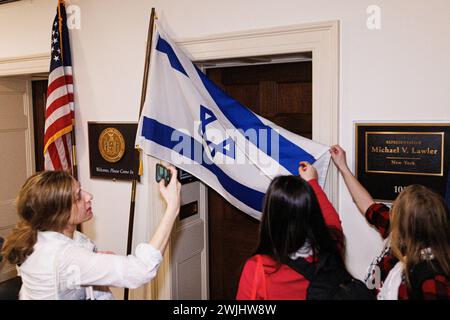 Ein pro-palästinensischer Demonstrant wirft eine israelische Flagge vor den Büros des US-Repräsentanten Mike Lawler (Republikaner von New York), während ein anderer am Donnerstag, den 15. Februar 2024, im Longworth House Office Building in Washington DC ein Foto macht. Quelle: Aaron Schwartz/CNP /MediaPunch Stockfoto
