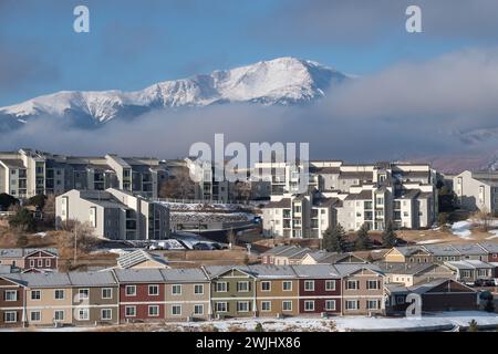 Ein Wintersturm zieht sich über den Pikes Peak in Colorado Springs. Apartments, Stadthäuser und Eigentumswohnungen in den Ausläufern bieten einen wunderschönen Blick auf die Berge. Stockfoto