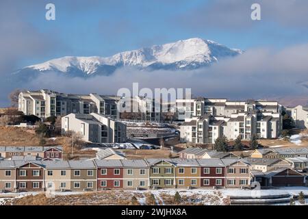 Ein Wintersturm zieht sich über den Pikes Peak in Colorado Springs. Apartments, Stadthäuser und Eigentumswohnungen in den Ausläufern bieten einen wunderschönen Blick auf die Berge. Stockfoto