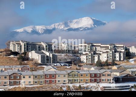 Ein Wintersturm zieht sich über den Pikes Peak in Colorado Springs. Apartments, Stadthäuser und Eigentumswohnungen in den Ausläufern bieten einen wunderschönen Blick auf die Berge. Stockfoto
