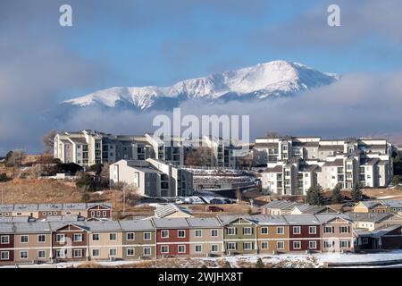Ein Wintersturm zieht sich über den Pikes Peak in Colorado Springs. Apartments, Stadthäuser und Eigentumswohnungen in den Ausläufern bieten einen wunderschönen Blick auf die Berge. Stockfoto