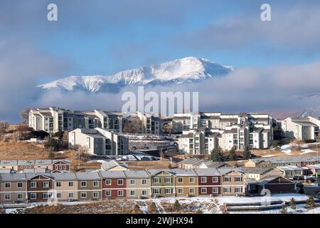 Ein Wintersturm zieht sich über den Pikes Peak in Colorado Springs. Apartments, Stadthäuser und Eigentumswohnungen in den Ausläufern bieten einen wunderschönen Blick auf die Berge. Stockfoto