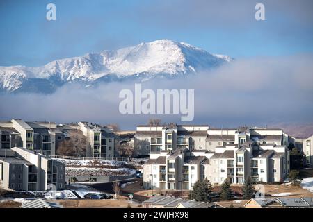 Ein Wintersturm zieht sich über den Pikes Peak in Colorado Springs. Apartments, Stadthäuser und Eigentumswohnungen in den Ausläufern bieten einen wunderschönen Blick auf die Berge. Stockfoto