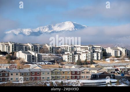 Ein Wintersturm zieht sich über den Pikes Peak in Colorado Springs. Apartments, Stadthäuser und Eigentumswohnungen in den Ausläufern bieten einen wunderschönen Blick auf die Berge. Stockfoto