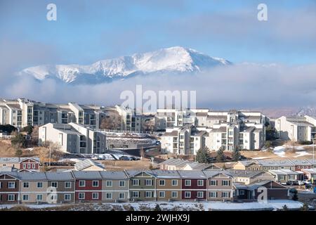 Ein Wintersturm zieht sich über den Pikes Peak in Colorado Springs. Apartments, Stadthäuser und Eigentumswohnungen in den Ausläufern bieten einen wunderschönen Blick auf die Berge. Stockfoto