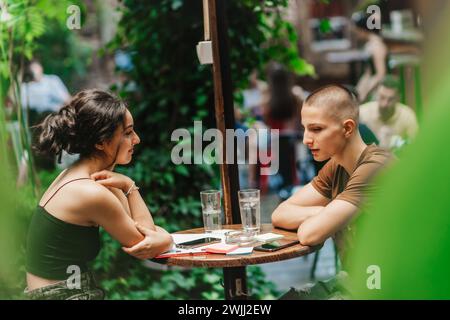 Schüler studieren und diskutieren verschiedene Themen nach dem Unterricht in einem Café, genießen ihre Freizeit und bereiten sich auf die Prüfungen vor. Stockfoto