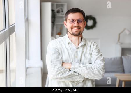 Schöner Mann in stilvoller Brille zu Hause Stockfoto