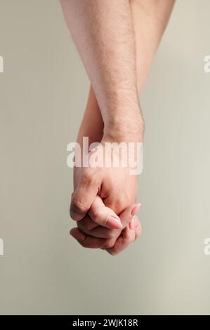 Nahaufnahme von Personen, die Hände halten. Zugeschnittenes Bild der Hände eines schönen Paares auf hellem Hintergrund. Stockfoto