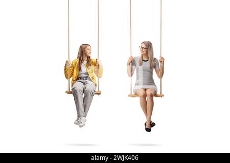 Ein Teenager-Mädchen und eine junge Frau, die auf Holzschaukeln sitzt, isoliert auf weißem Hintergrund Stockfoto