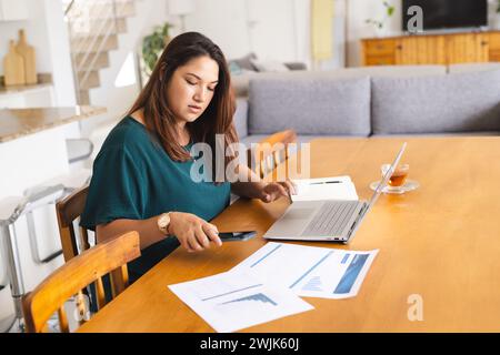 Eine junge Frau arbeitet zu Hause an einem Laptop Stockfoto