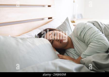 Eine junge Frau in Übergröße schläft friedlich in einem gemütlichen, unveränderten Zuhause Stockfoto