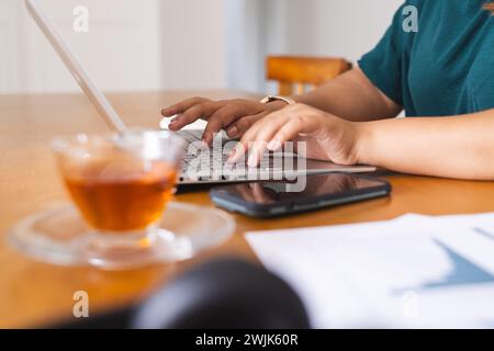 Die junge Frau arbeitet zu Hause an ihrem Laptop Stockfoto