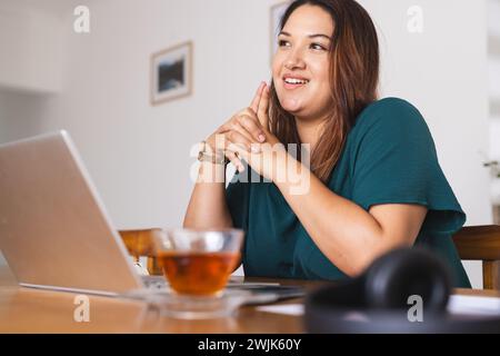 Die junge Frau arbeitet zu Hause an ihrem Laptop Stockfoto