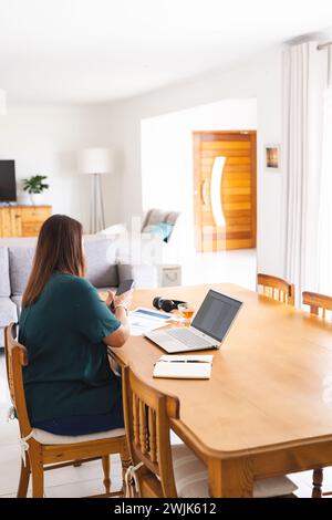 Junge Frau, die von zu Hause aus arbeitet, mit Kopierraum Stockfoto