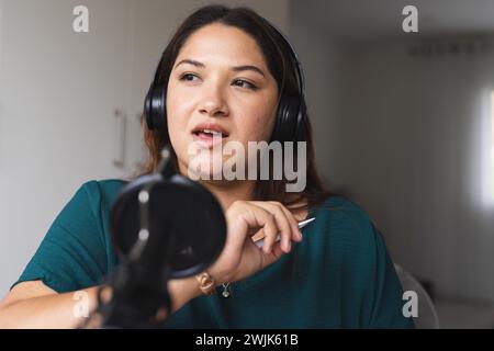 Eine junge birassische Frau nimmt zu Hause einen Podcast auf Stockfoto