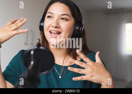 Junge birassische und große Frau nimmt zu Hause einen Podcast auf, mit unverändertem Kopierraum Stockfoto