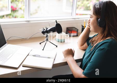 Die junge Frau nimmt einen Podcast von zu Hause auf Stockfoto