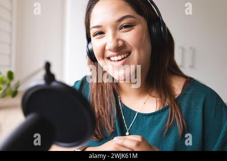 Eine junge birassische Frau nimmt zu Hause einen Podcast auf Stockfoto