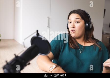 Eine junge birassische Frau nimmt zu Hause einen Podcast auf Stockfoto