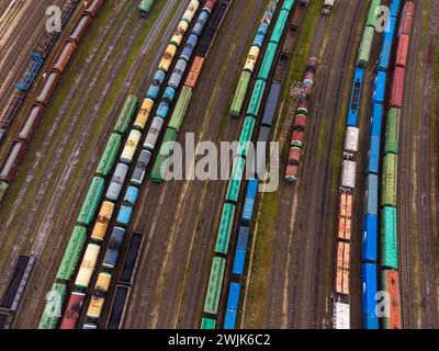 Lebendige Luftaufnahme mehrerer Güterzüge auf Gleisen, die Logistik- und Transportinfrastruktur zeigen. Stockfoto