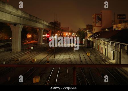 Unter dem Schleier der Nacht durchquert der Zug der Stadt Medan die Dunkelheit, seine Lichter malen Lichtstreifen, ein nächtliches Spektakel. Stockfoto