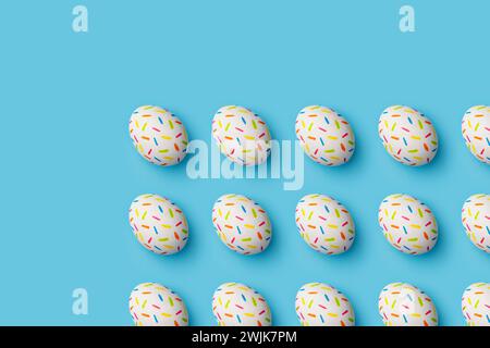 Bestreuen Sie bunte ostereier auf blauem Hintergrund. Direkt über der Tischplatte. Stockfoto