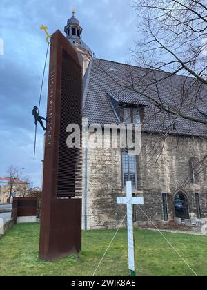 16. Februar 2024, Thüringen, Mühlhausen: Vor der Jugendkirche in Mühlhausen steht ein Kreuz, das Anfang April 2023 zum Gedenken an die Toten eines Autounfalls bei Bad Langensalza in Thüringen aufgestellt wurde. Die Klageschrift und das Urteil werden am Freitag vor dem Amtsgericht Mühlhausen in der Verhandlung um einen Autounfall bei einem Horrorunfall erwartet, bei dem sieben Menschen ums Leben kamen. Die Staatsanwaltschaft wirft dem Angeklagten vor, das Auto zu fahren, das den Unfall verursacht hat, während er betrunken und zu schnell war. Er hatte auch keinen Führerschein. Der 35-Jährige wird wegen sieben unfreiwilligen M angeklagt Stockfoto