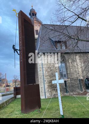 16. Februar 2024, Thüringen, Mühlhausen: Vor der Jugendkirche in Mühlhausen steht ein Kreuz, das Anfang April 2023 zum Gedenken an die Toten eines Autounfalls bei Bad Langensalza in Thüringen aufgestellt wurde. Die Klageschrift und das Urteil werden am Freitag vor dem Amtsgericht Mühlhausen in der Verhandlung um einen Autounfall bei einem Horrorunfall erwartet, bei dem sieben Menschen ums Leben kamen. Die Staatsanwaltschaft wirft dem Angeklagten vor, das Auto zu fahren, das den Unfall verursacht hat, während er betrunken und zu schnell war. Er hatte auch keinen Führerschein. Der 35-Jährige wird wegen sieben Verurteilungen wegen unfreiwilligen Mannes angeklagt Stockfoto