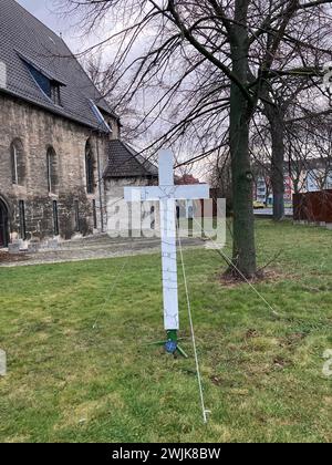 16. Februar 2024, Thüringen, Mühlhausen: Vor der Jugendkirche in Mühlhausen steht ein Kreuz, das Anfang April 2023 zum Gedenken an die Toten eines Autounfalls bei Bad Langensalza in Thüringen aufgestellt wurde. Die Klageschrift und das Urteil werden am Freitag vor dem Amtsgericht Mühlhausen in der Verhandlung um einen Autounfall bei einem Horrorunfall erwartet, bei dem sieben Menschen ums Leben kamen. Die Staatsanwaltschaft wirft dem Angeklagten vor, das Auto zu fahren, das den Unfall verursacht hat, während er betrunken und zu schnell war. Er hatte auch keinen Führerschein. Der 35-Jährige wird wegen sieben unfreiwilligen M angeklagt Stockfoto