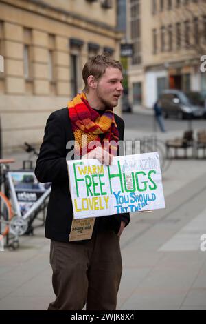 Newcastle-under-Lyme, Staffordshire-united Kingdom Oktober, 20, 2023 Ein Mann steht in der Hauptstraße mit einem Schild, das kostenlose Umarmungen und psychische Gesundheit anbietet Stockfoto