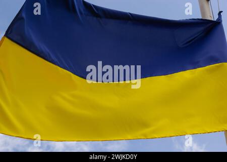 Ukrainische Flagge winkt bei Wind und Sonnenlicht. Flagge der Ukraine auf blauem Himmel Hintergrund. Nationales Symbol für Freiheit und Unabhängigkeit. Stockfoto