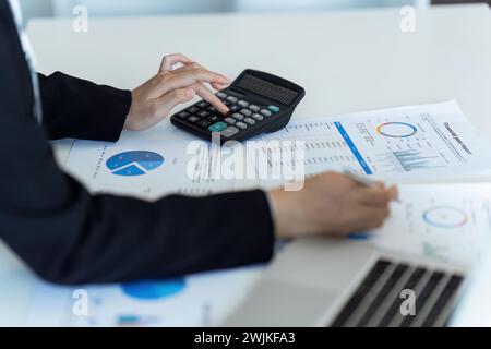 Geschäftsfrau übergibt mit einem Rechner die Finanzen, die Einnahmen und das Budget des Unternehmens Stockfoto