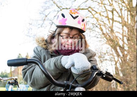 Außenporträt einer 41-Jährigen Frau mit Down-Syndrom, die auf ihrem Tricyl sitzt, Tienen, Belgien Stockfoto