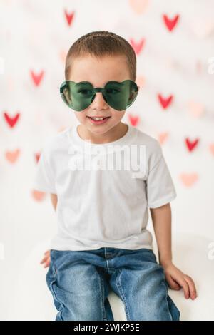 Porträt eines lächelnden Jungen mit herzförmiger Sonnenbrille Stockfoto