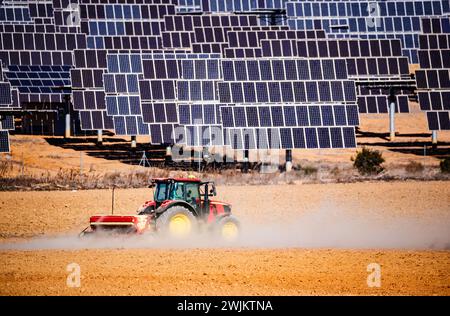 Traktor pflügt ein Feld neben einem Solarpark in El Bonete Stockfoto