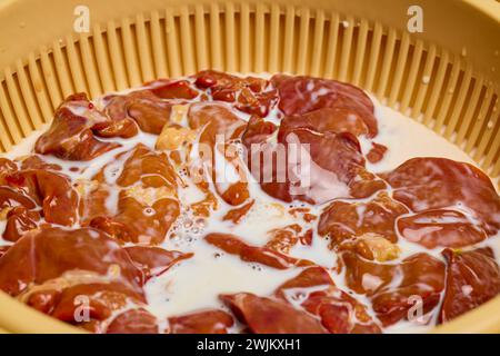 Hühnerleber in Milch in einer Schüssel, fertig zum Kochen. Stockfoto