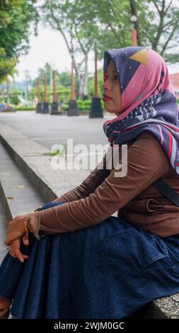 12. September 2020, eine asiatische Frau mittleren Alters im Urlaub in einem Stadtpark mit Gesundheitsmaske in Kebumen, Zentraljava, Indonesien Stockfoto