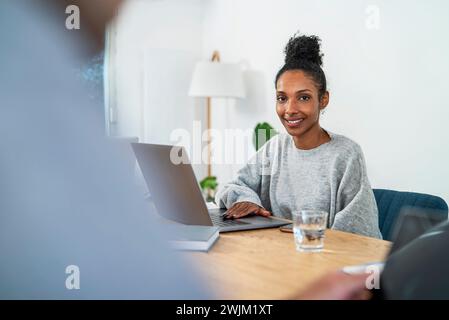 Finanzassistent sitzt am Schreibtisch mit Laptop Stockfoto