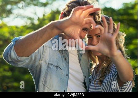 Erwachsenes Paar, das zusammen steht und mit den Händen eine Herzform bildet Stockfoto