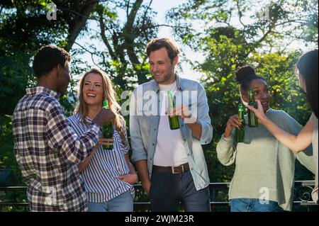 Eine Gruppe von Freunden versammelte sich draußen und trank Bier Stockfoto