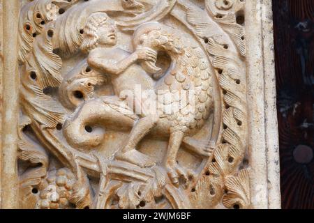 Ein Mann, der gegen die Versuchungen und das Böse kämpft - Detail der „portale Maggiore“ (Haupteingang) - Kathedrale von Modena, ein Juwel im romanischen Stil Stockfoto