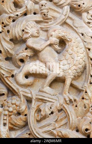 Ein Mann, der gegen die Versuchungen und das Böse kämpft - Detail der „portale Maggiore“ (Haupteingang) - Kathedrale von Modena, ein Juwel im romanischen Stil Stockfoto