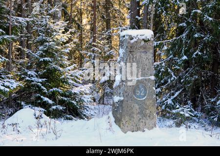 Alter Meilenstein an der finnischen Nationalstraße 52, der Hauptstraße zwischen Raseborg und der Gemeinde Jokioinen im Südwesten Finnlands, am Wintermorgen. Stockfoto