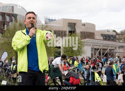 Alex Cole-Hamilton MSP und Vorsitzender der schottischen Liberaldemokraten spricht mit Hunderten von Radfahrern und Menschen mit Fahrrädern außerhalb des Parlaments, die Cyc haben Stockfoto