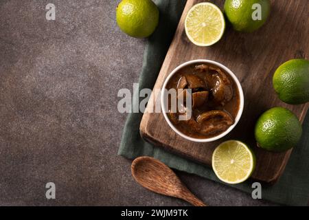 Hausgemachte Limettenpickle auf braunem Hintergrund. Ceylon Küche. Kopierbereich. Draufsicht. Stockfoto