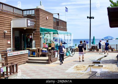 Gangneung City, Südkorea - 29. Juli 2019: Besucher schlendern durch den Innenhof der Songjeong Watermill Raststätte, flankiert von Restaurants und Erholung Stockfoto