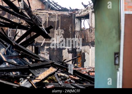 Neermoor, Deutschland. Februar 2024. Verkohlte Holzbalken der Dachkonstruktion liegen in der abgebrannten Sporthalle der Grundschule in Neermoor. Ein Brand zerstörte gestern Abend das Gymnasium in der Neermoor-Grundschule. Starke Winde und leicht brennbare Baumaterialien in der Halle führten dazu, dass sich das Feuer in eine größere Flamme mit fliegenden Funken und starkem Rauch ausbreitete. Quelle: Hauke-Christian Dittrich/dpa/Alamy Live News Stockfoto