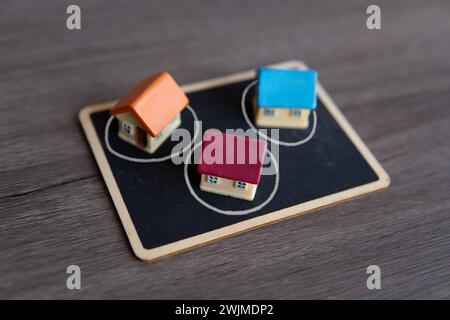 Nahaufnahme des Spielzeughauses und der Tafel. Immobilienblase, Immobilienblase Konzept. Stockfoto