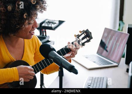Musikerin, Sängerin, die Musik am Mikrofon aufnimmt. Klangqualität Stockfoto
